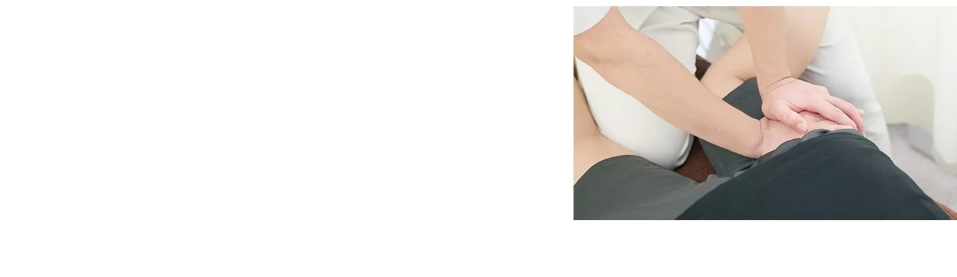 사람이 다른 사람의 등을 손으로 지압하고 있는 모습입니다. 손은 겹쳐져 있으며, 검은색 옷을 입은 사람이 눕혀져 있습니다. 배경은 밝은 색상입니다.