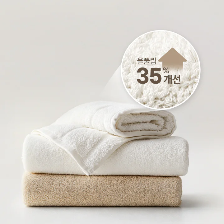 이미지 중앙에 부드러운 재질의 수건이 접힌 채 쌓여있으며, 상단에는 "올플림 35% 개선" 이라는 텍스트와 함께 상단 방향의 텍스트 이미지가 보여집니다.